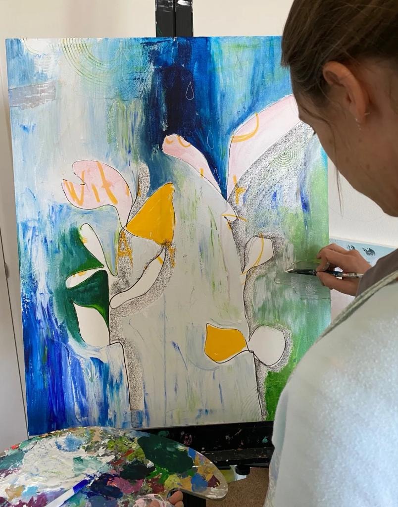 Lotte Goede painting at her easel in her studio